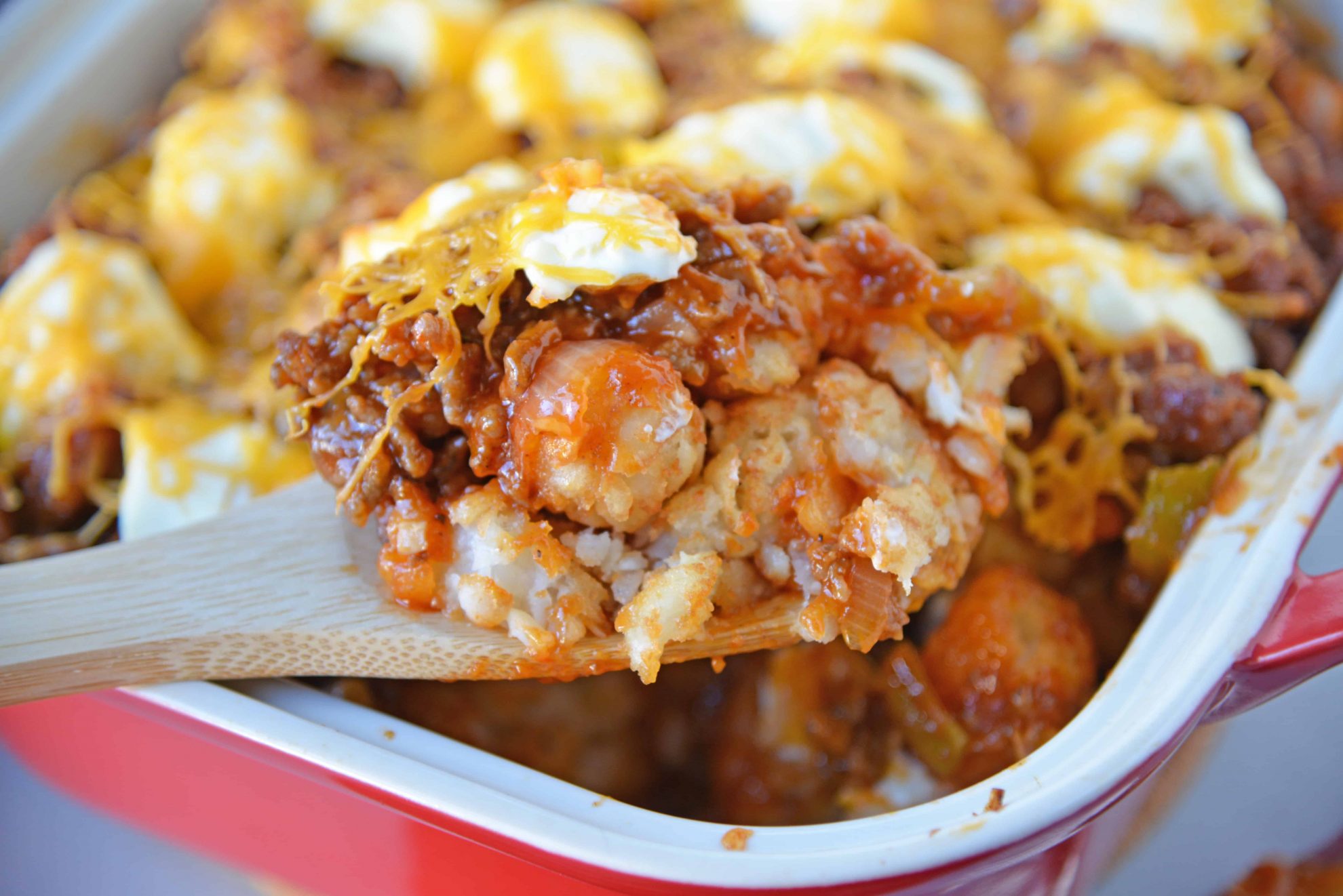 Sloppy Joe Tater Tot Casserole combines layers of crispy tater tots with homemade sloppy Joe mix, cream cheese and cheddar for the ultimate quick meal or party food! #tatertotcasserole #sloppyjoes www.savoryexperiments.com 
