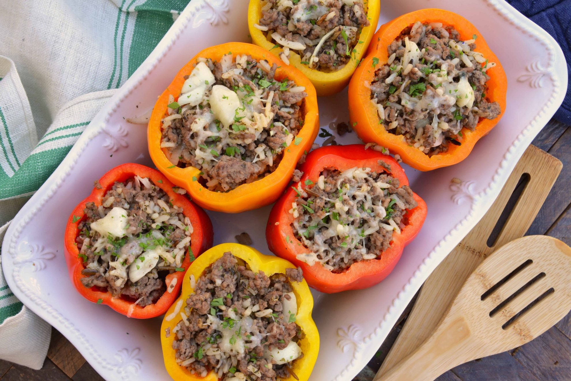 Classic Stuffed Peppers are bell peppers stuffed with ground beef, rice, cheese and spices. A timeless meal ready in 30 minutes and easily made ahead. #stuffedpeppers #stuffedbellpeppers www.savoryexperiments.com