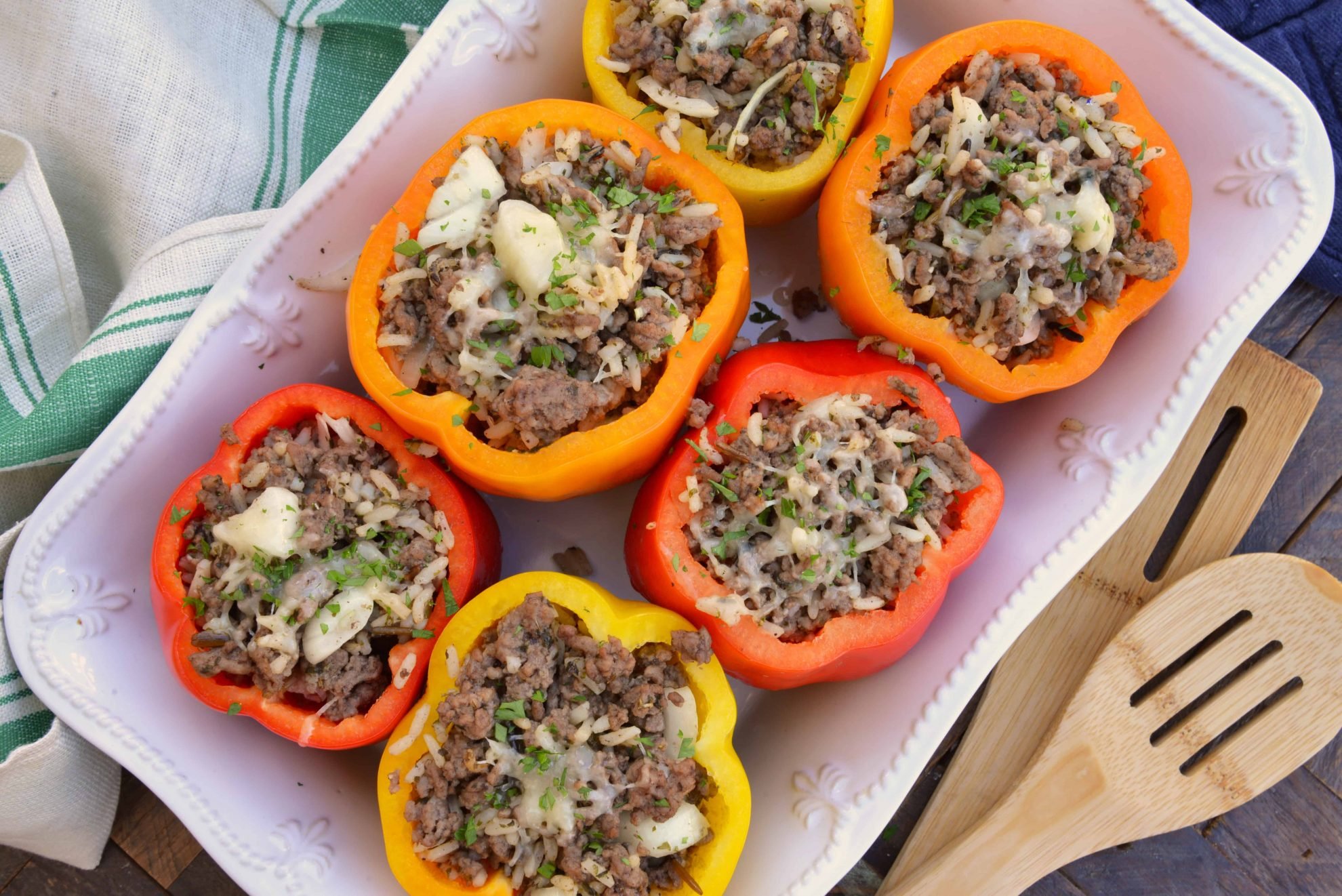 Classic Stuffed Peppers are bell peppers stuffed with ground beef, rice, cheese and spices. A timeless meal ready in 30 minutes and easily made ahead. #stuffedpeppers #stuffedbellpeppers www.savoryexperiments.com 