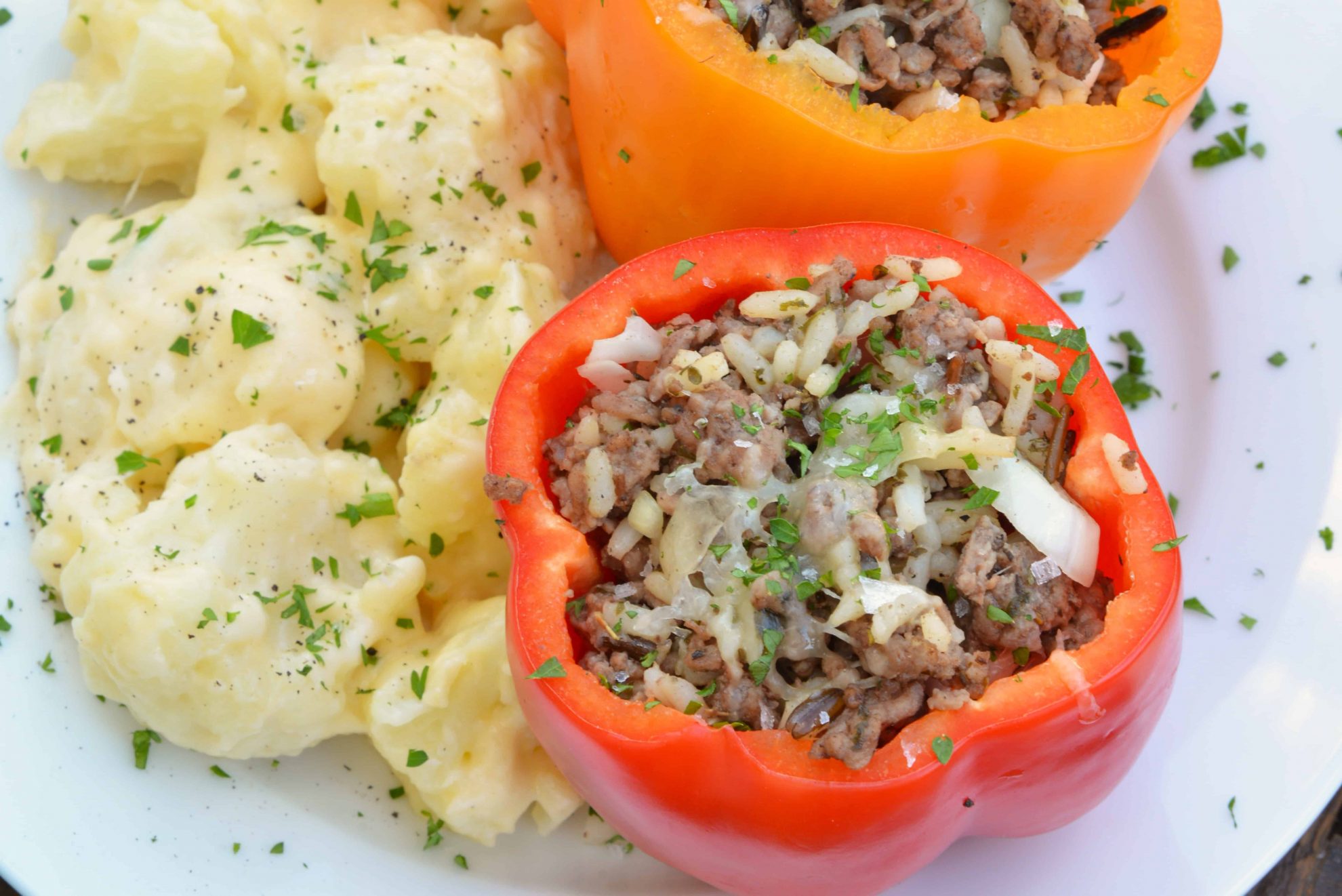 Classic Stuffed Peppers are bell peppers stuffed with ground beef, rice, cheese and spices. A timeless meal ready in 30 minutes and easily made ahead. #stuffedpeppers #stuffedbellpeppers www.savoryexperiments.com 