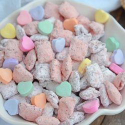 Valentine's Day Puppy Chow transforms a traditional muddy buddy recipe into a festive Cupid Crunch mix! The perfect no-bake dessert for any Valentine's Day party. #puppychow #valentinesdaydesserts #muddybuddy #nobakedesserts www.savoryexperiments.com