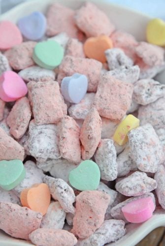 Valentine's Day Puppy Chow transforms a traditional muddy buddy recipe into a festive Cupid Crunch mix! The perfect no-bake dessert for any Valentine's Day party. #puppychow #valentinesdaydesserts #muddybuddy #nobakedesserts www.savoryexperiments.com