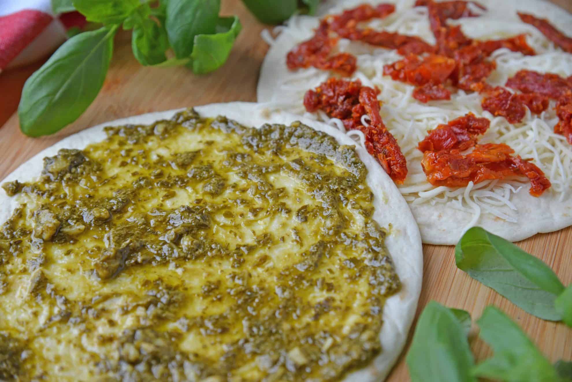 Caprese Quesadillas combine homemade pesto sauce with sun dried tomatoes and gooey mozzarella cheese. Serve for lunch, dinner or even as a party appetizer! #quesadillarecipe #capresequesadilla www.savoryexperiments.com 