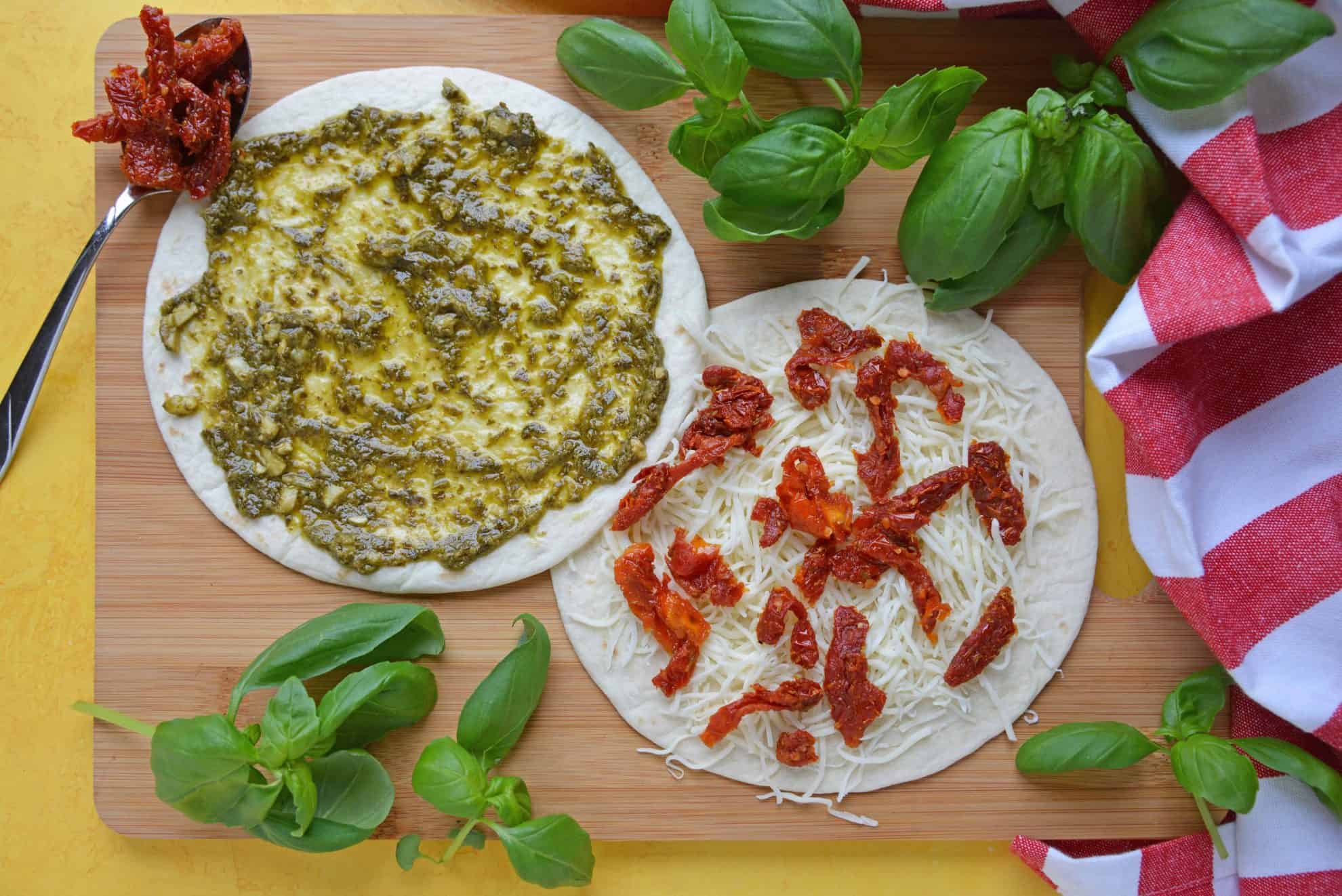 Caprese Quesadillas combine homemade pesto sauce with sun dried tomatoes and gooey mozzarella cheese. Serve for lunch, dinner or even as a party appetizer! #quesadillarecipe #capresequesadilla www.savoryexperiments.com 