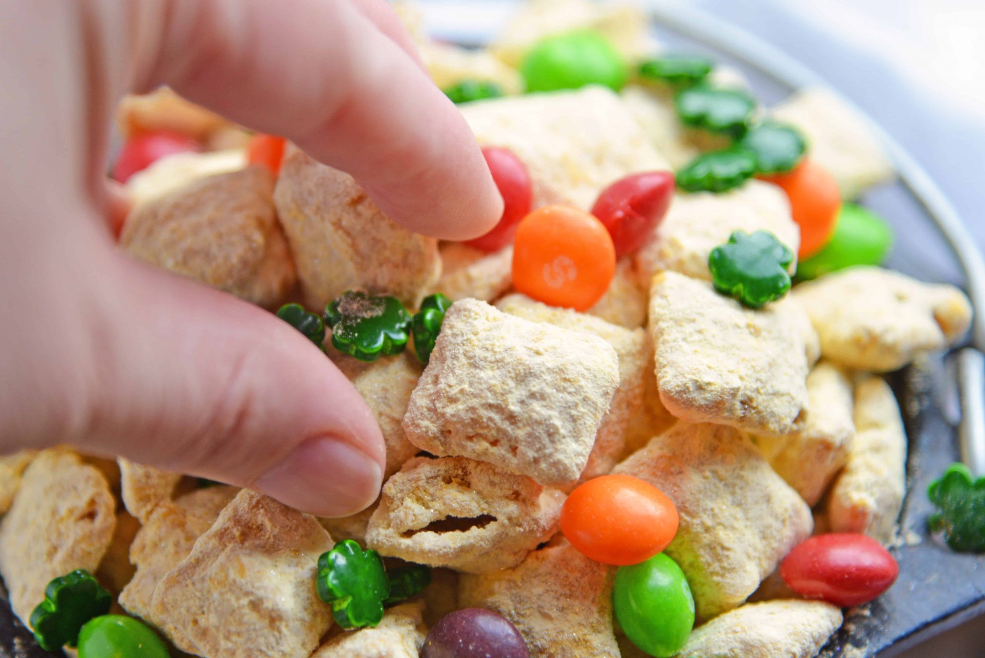 Hand reaching for a bite of gold puppy chow 