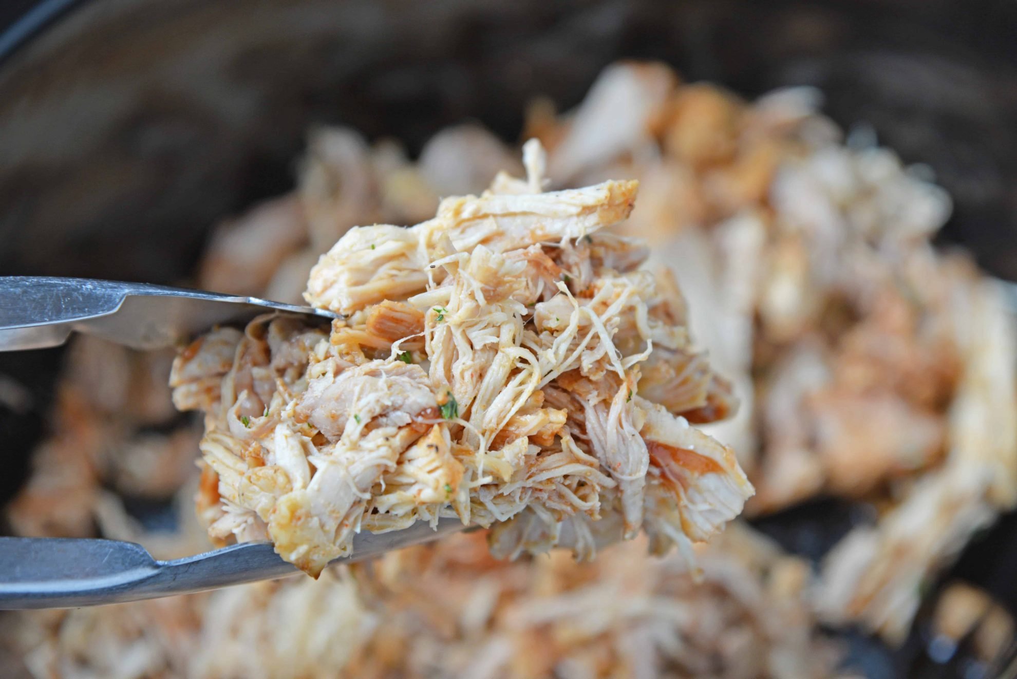 Pulled chicken in tongs