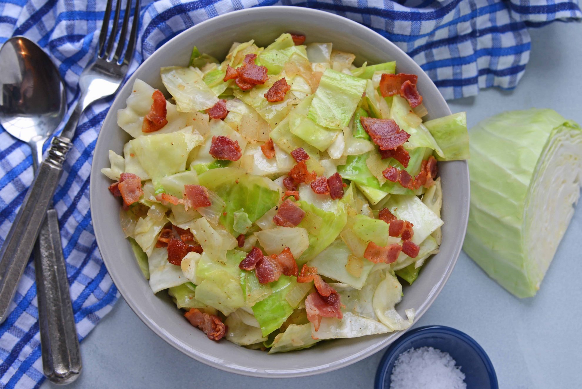 Overhead of bacon fried cabbage with blue napkin