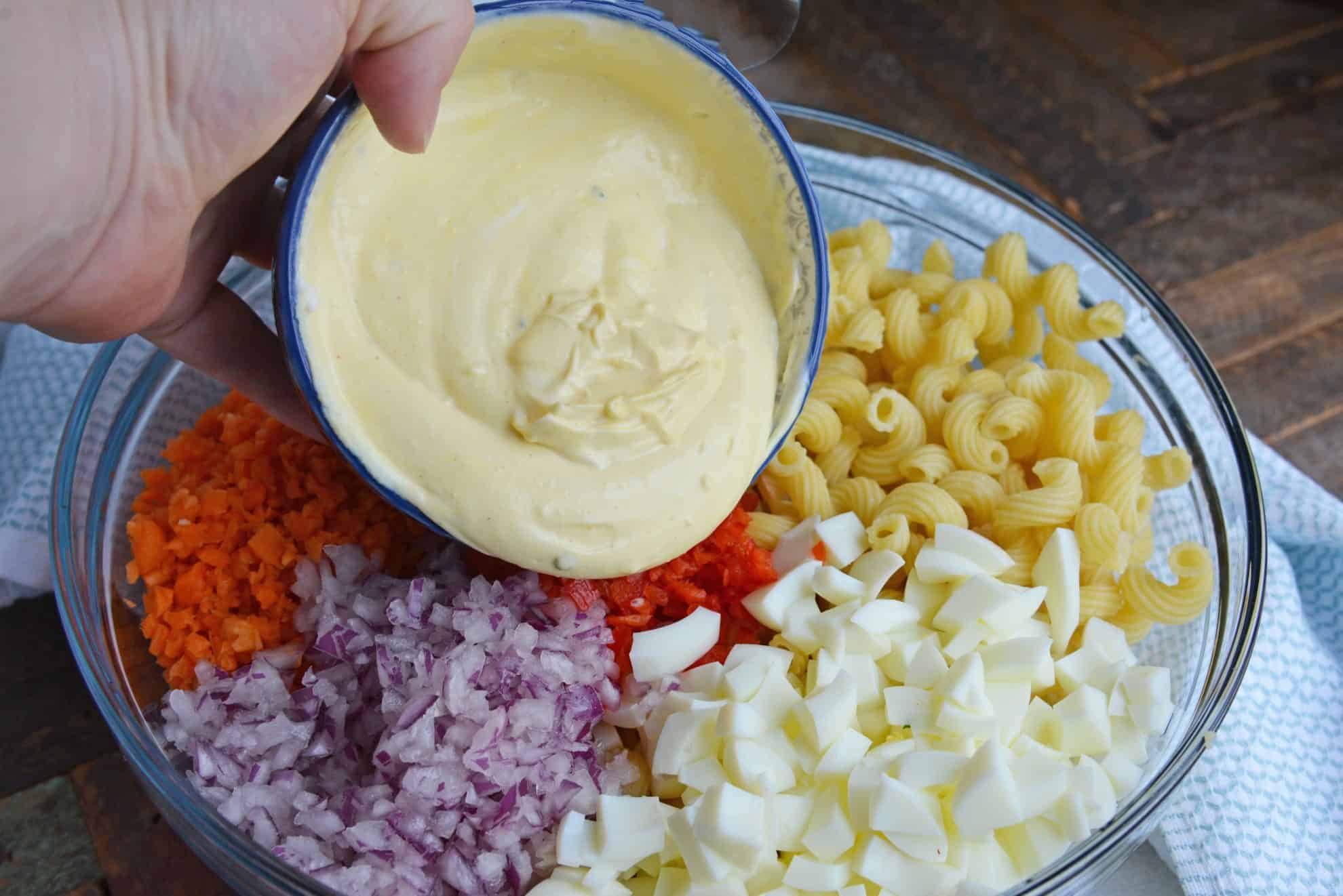 Pouring yolk mixture onto macaroni salad