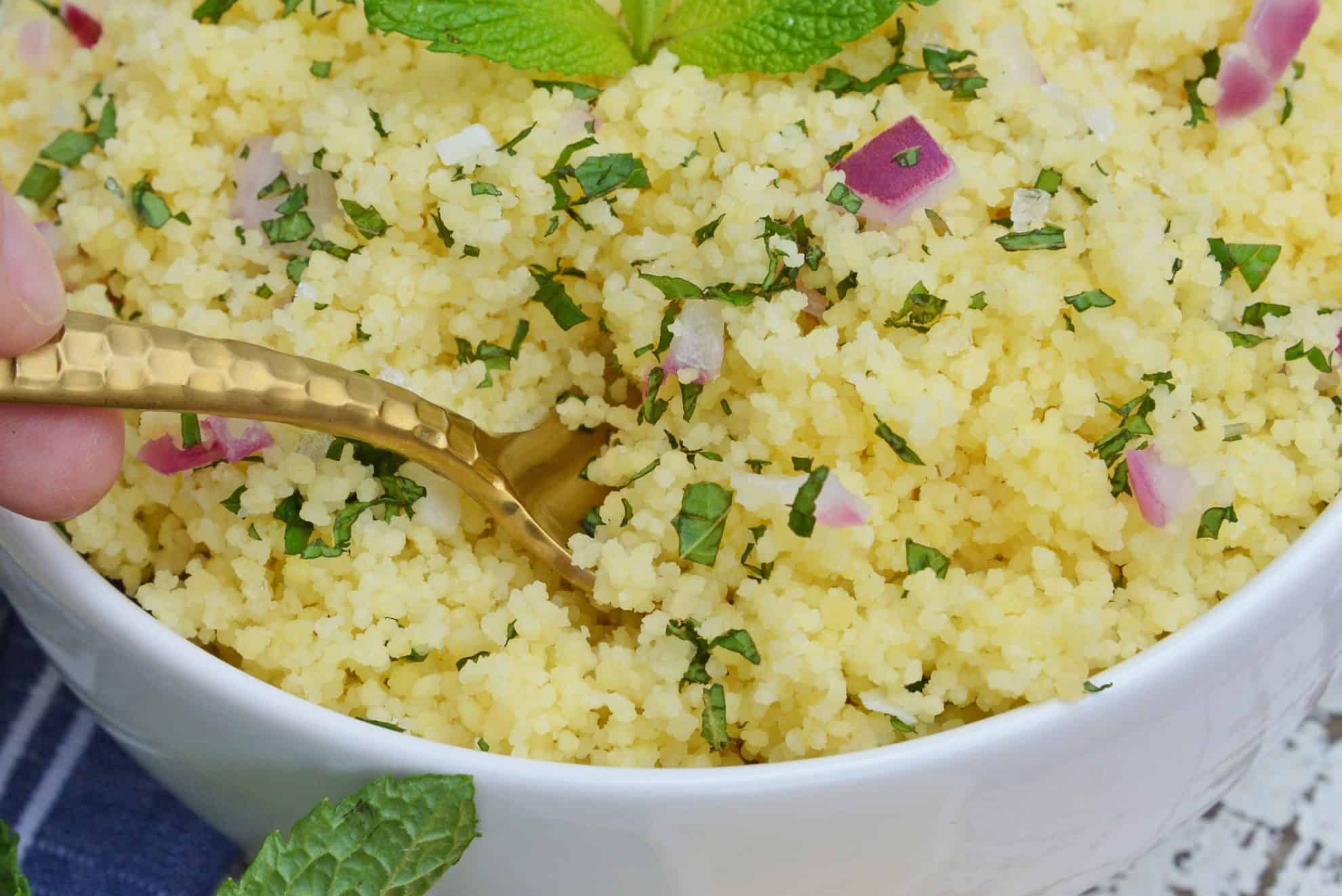 Couscous with mint and red onion in a gold spoon