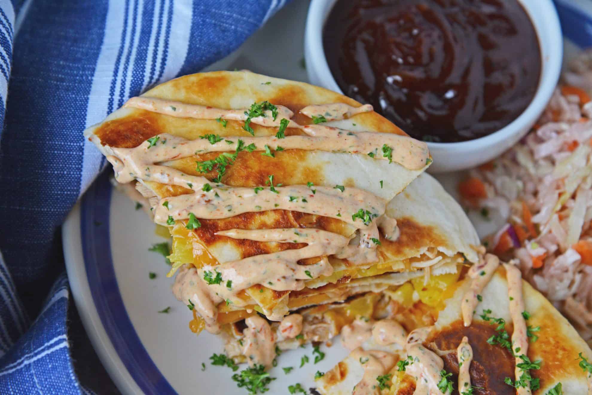 A close up of a plate of food, with Quesadilla and Burrito