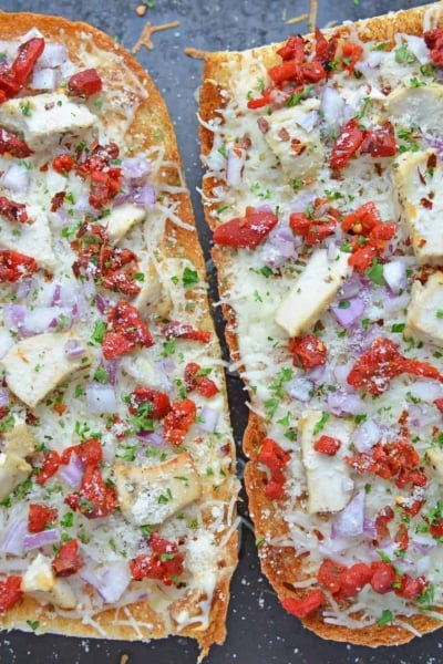 Two french bread pizzas on a baking sheet