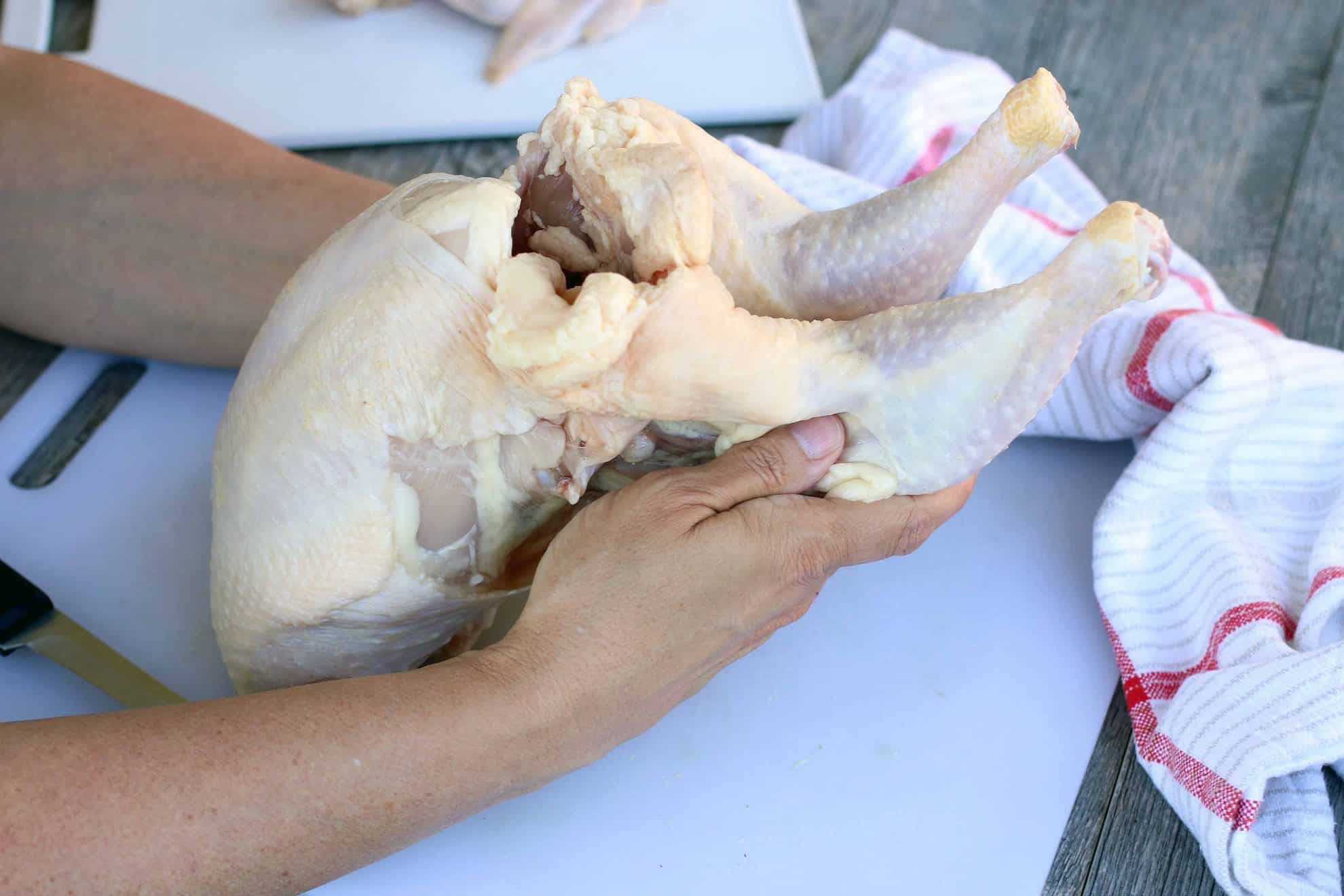 Separating the leg from the thigh of a whole chicken.