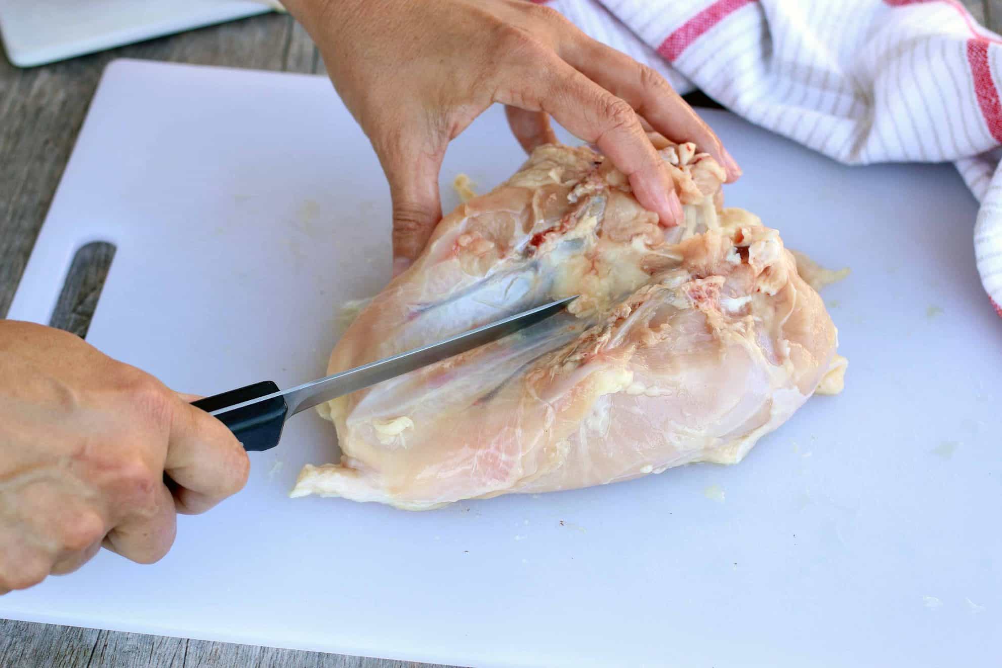 Removing the keel bone to split the breast of a chicken.