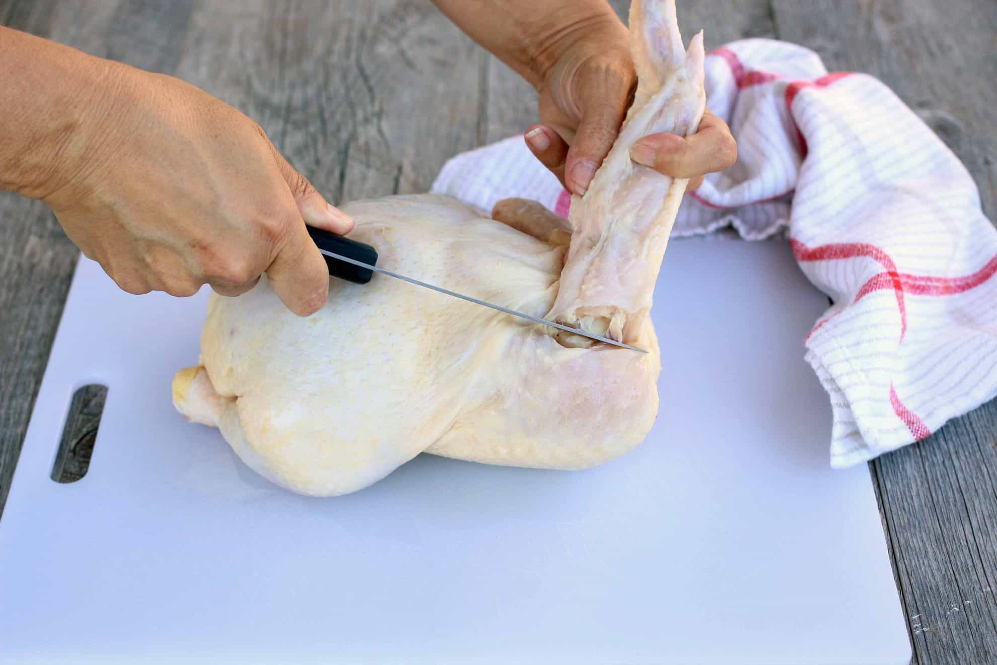Separating the leg from the thigh of a whole chicken.