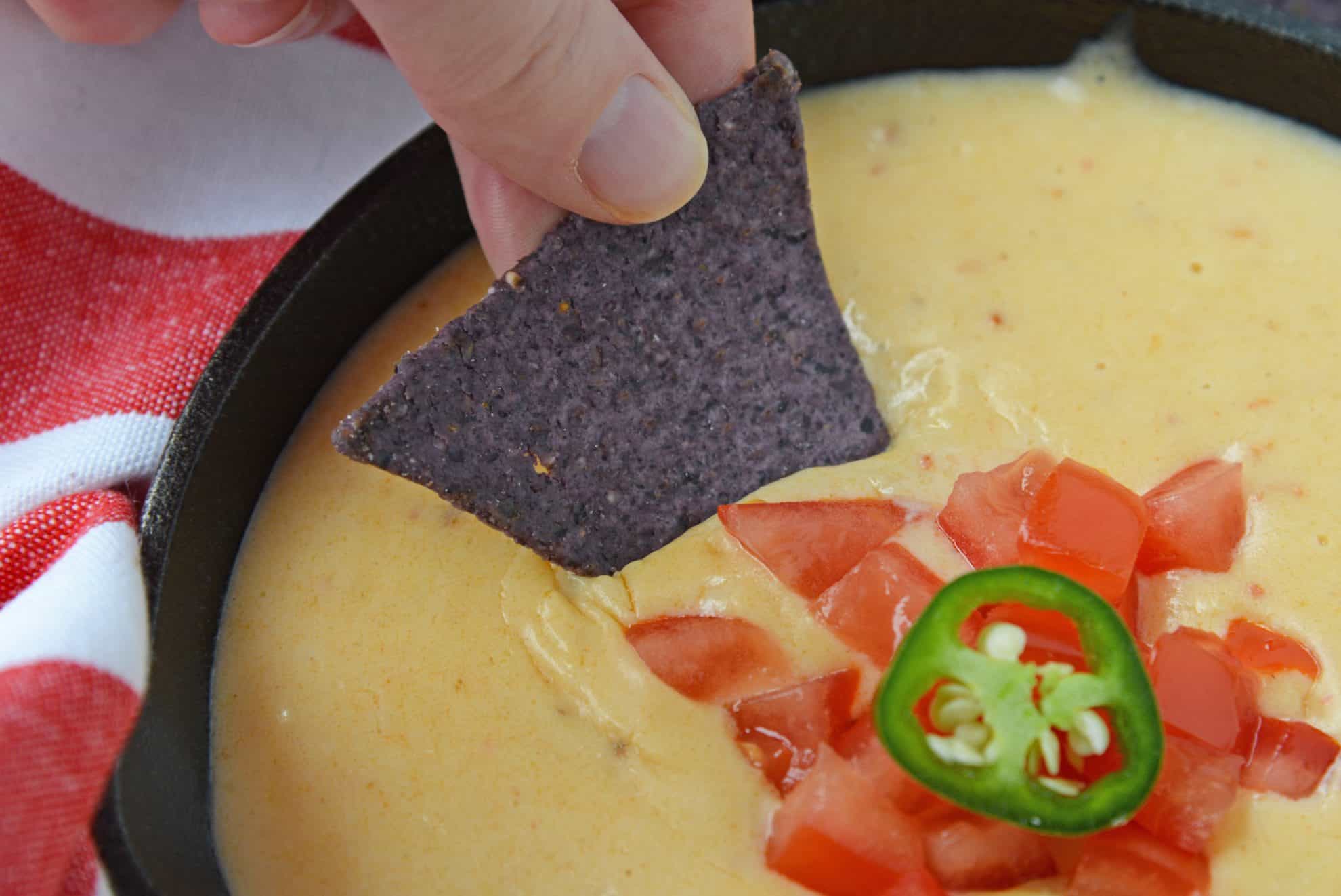Chip dipping into Mexican queso sauce