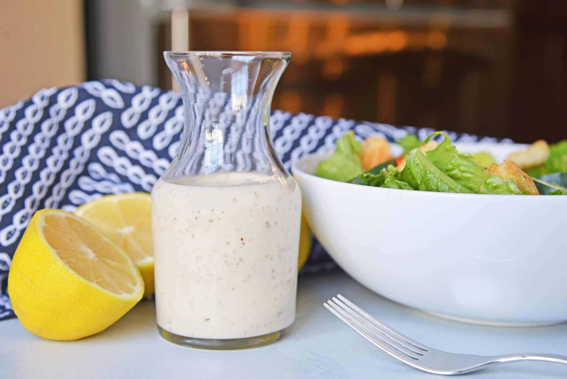 A glass of salad dressing on a table,