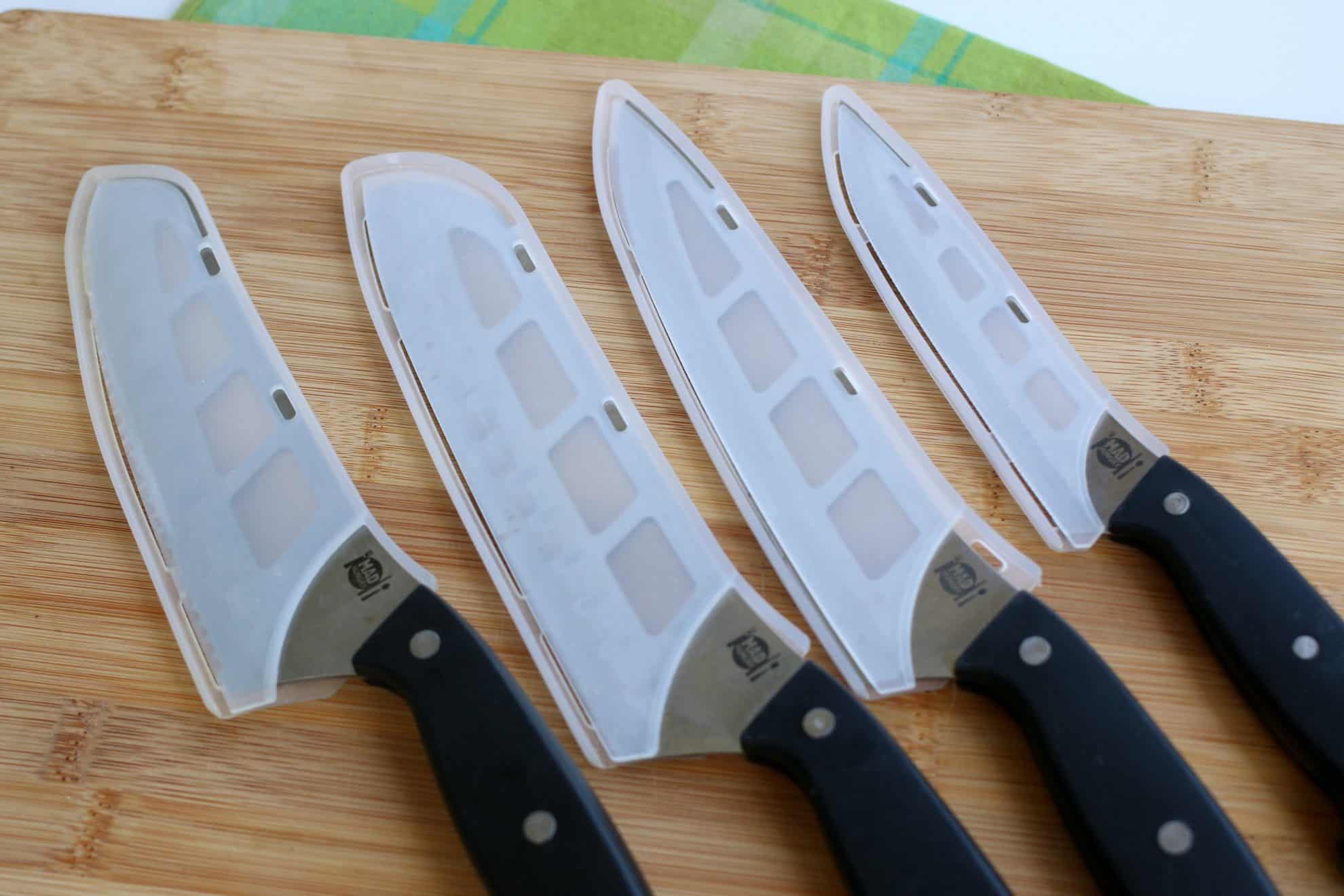 Kitchen knives in protective covers for storing inbetween use.