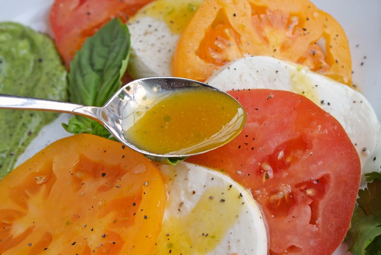 Spooning passion fruit dressing on salad 