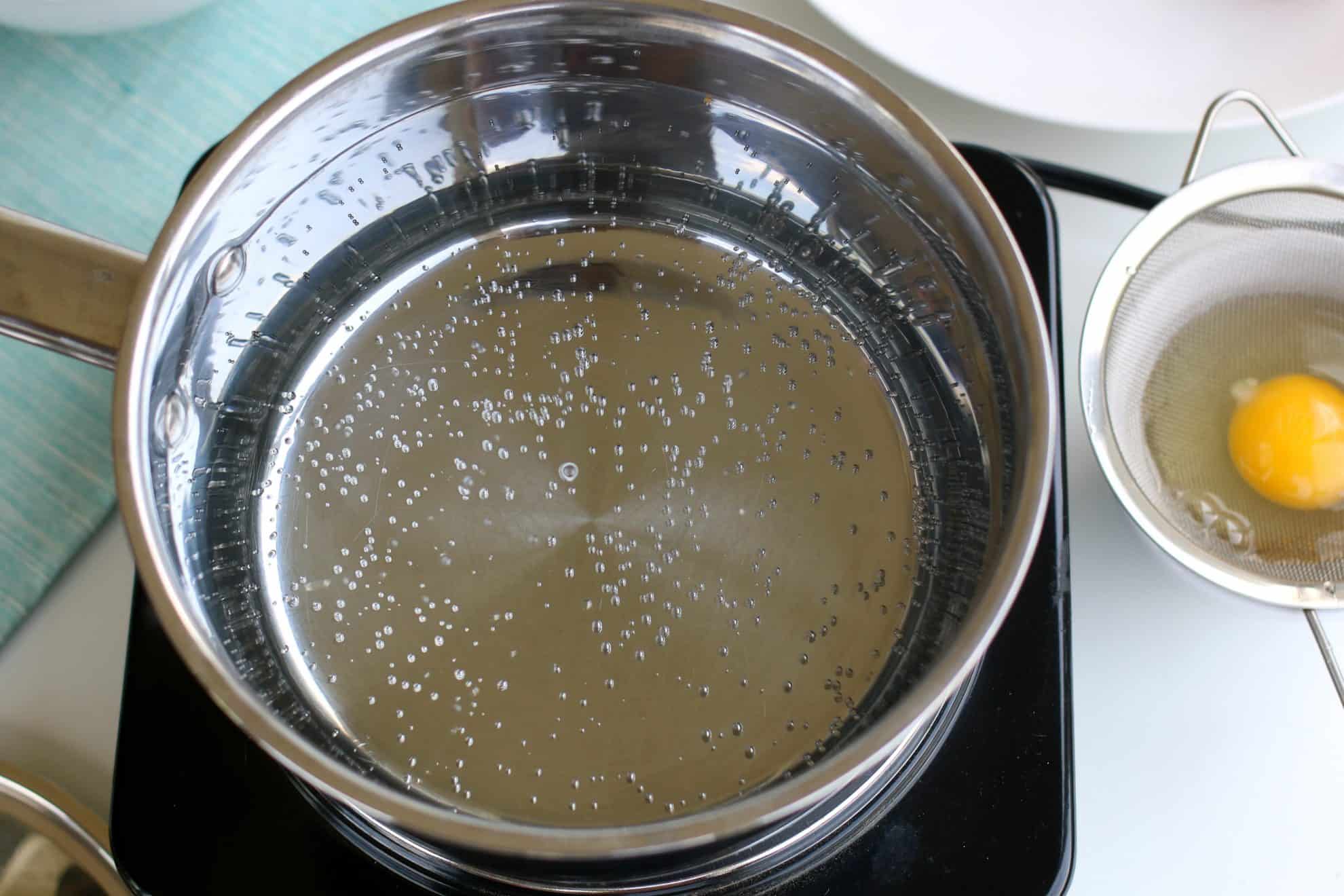 Water simmering on the stove ready to poach eggs