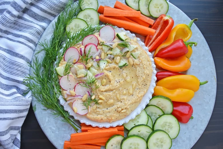 Overhead of hummus with toppings and crudites