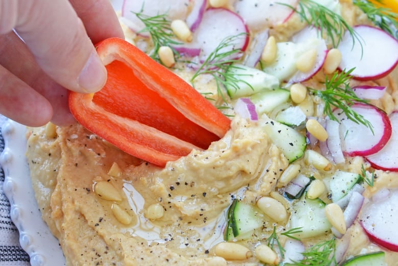 sweet pepper dipping into hummus