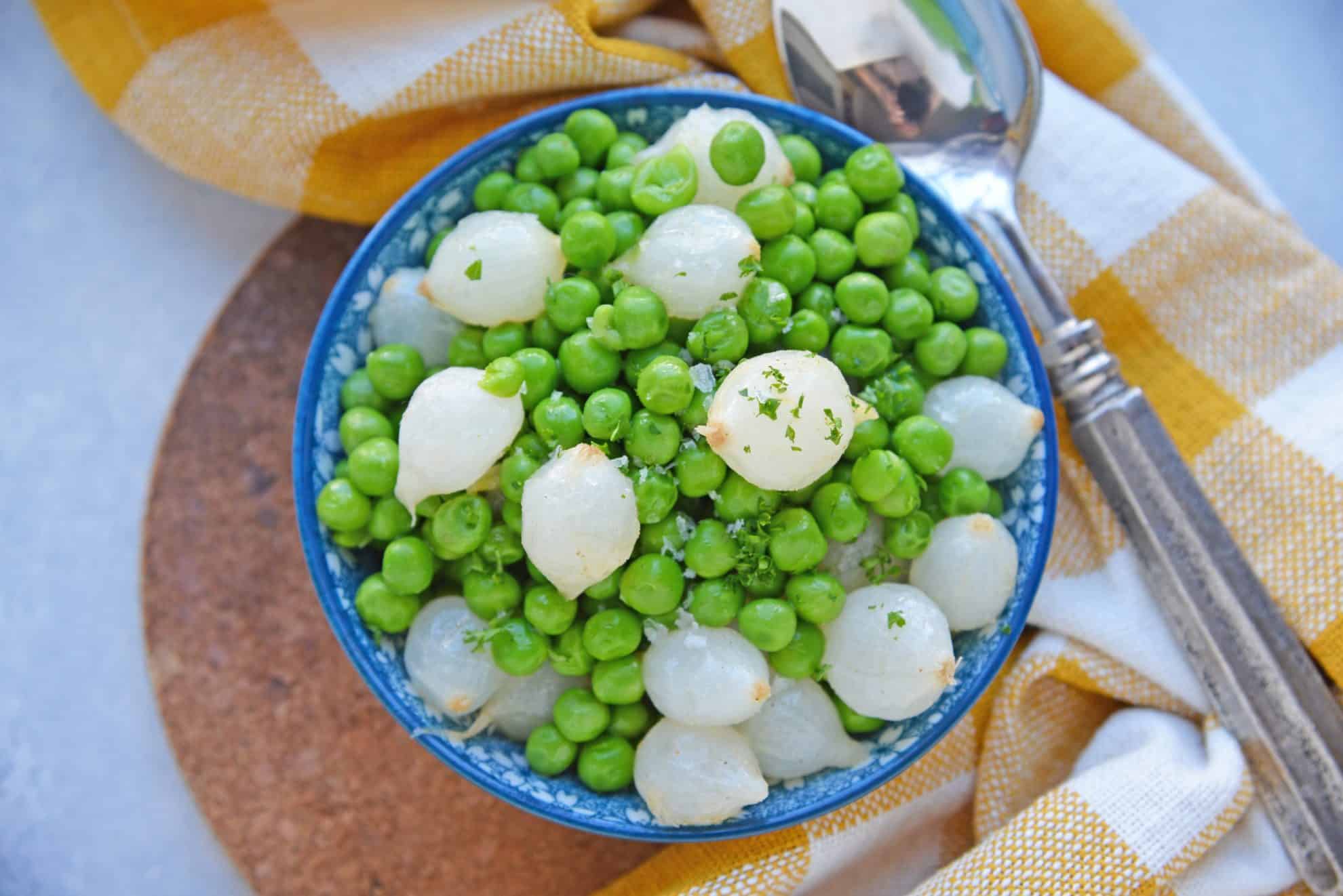 Overhead of peas and onions in a blue bowl