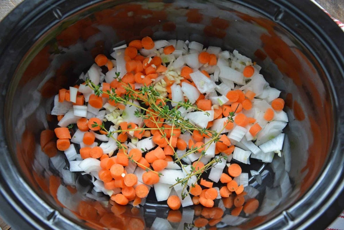 Carrots, onion, thyme and garlic in a slow cooker