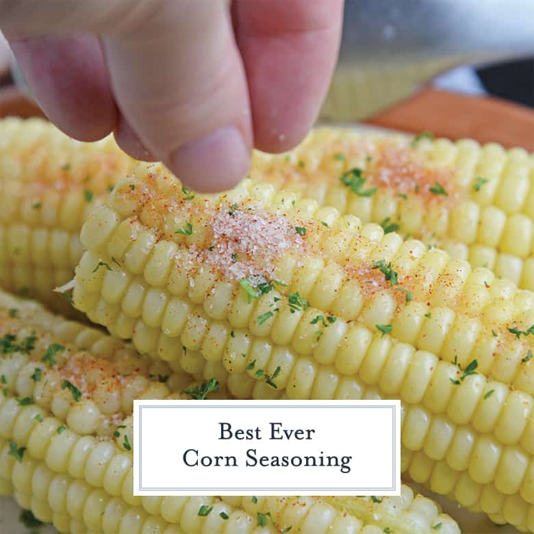 sprinkling corn seasoning on an ear of corn