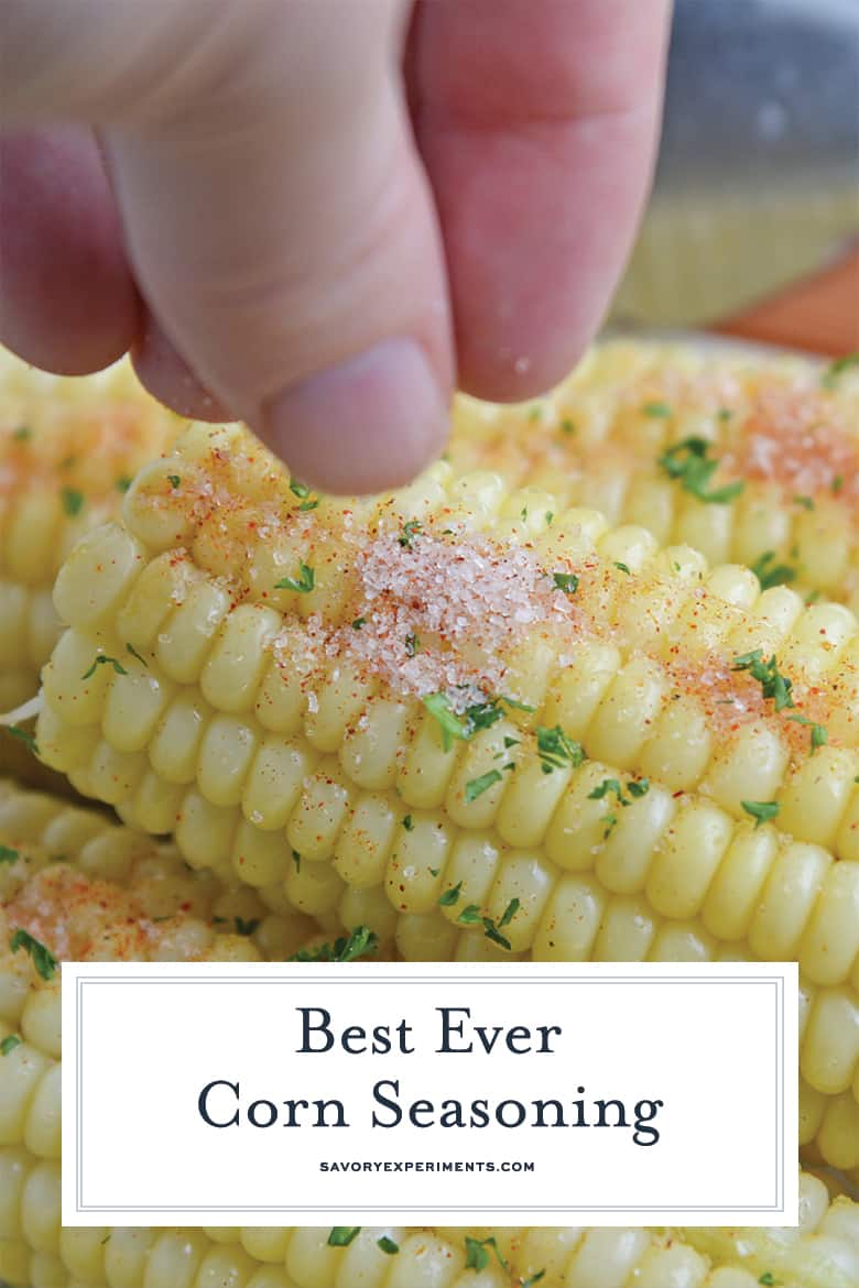 sprinkling corn seasoning on an ear of corn 