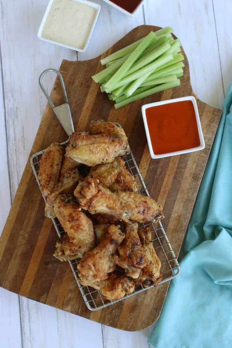 Overhead view of air fryer wings with celery and sauce