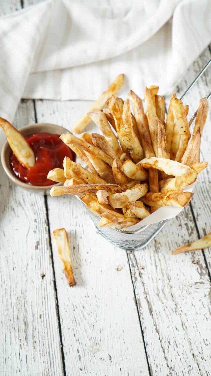 Air fryer french fries in a basket with ketchup