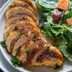 sliced air fryer chicken on a plate with salad