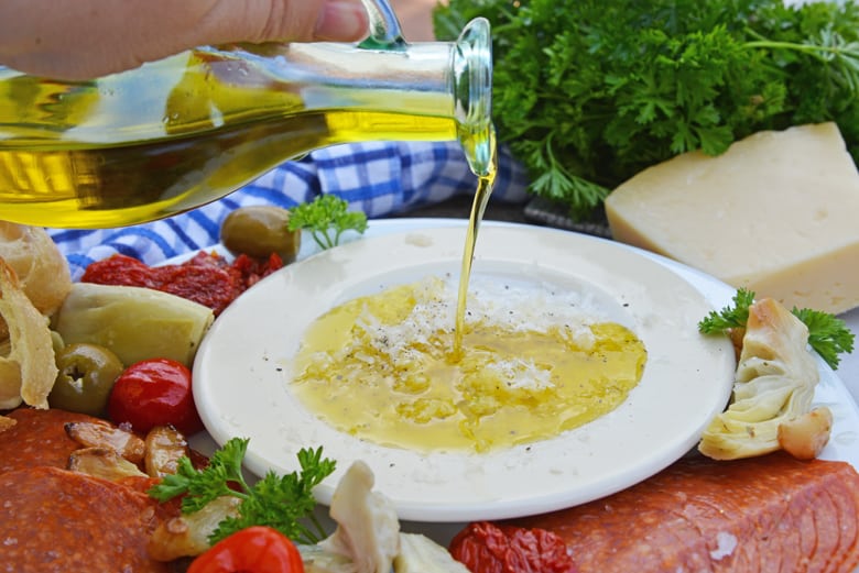 Olive oil pouring into garlic parmesan mix