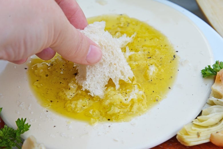 Bread being dipped into olive oil bread dip