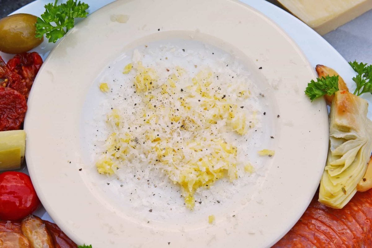 Parmesan cheese and fresh garlic on a white plate