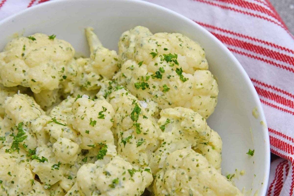 Green curry cauliflower in a white serving bowl 