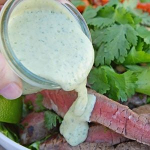 green curry sauce pouring over steak