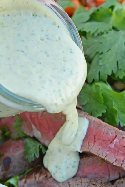 green curry sauce pouring over steak