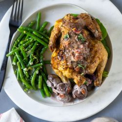 overhead shot of air fryer cornish hen with green beans