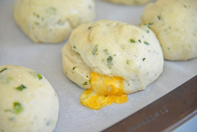 Jalapeno bread on a baking sheet oozing with cheese 