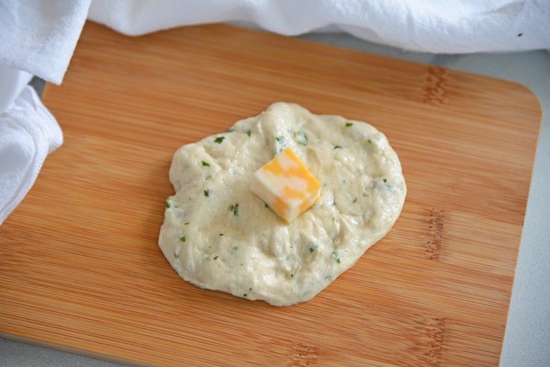 Bread dough with cheese on a cutting board