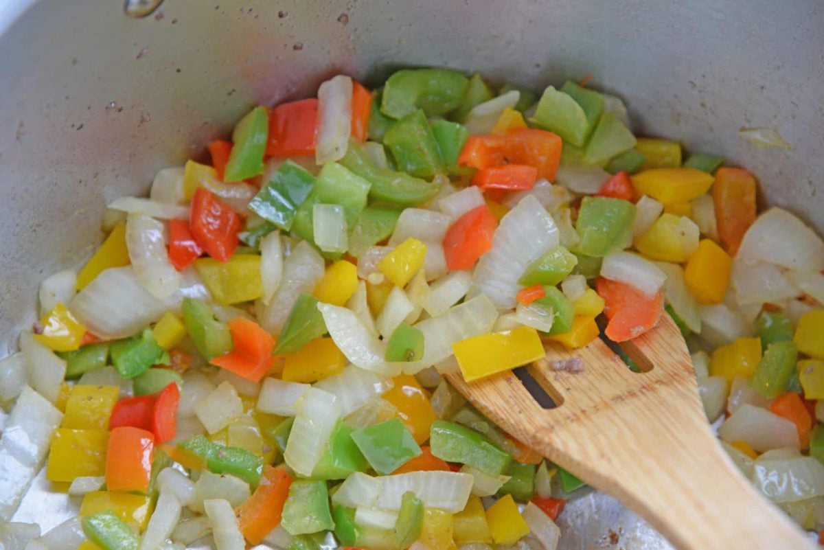 angled shot of wooden spoon in pot of sautéing vegetables