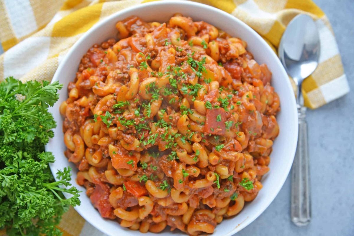 Overhead shot of American goulash in a white serving dish 