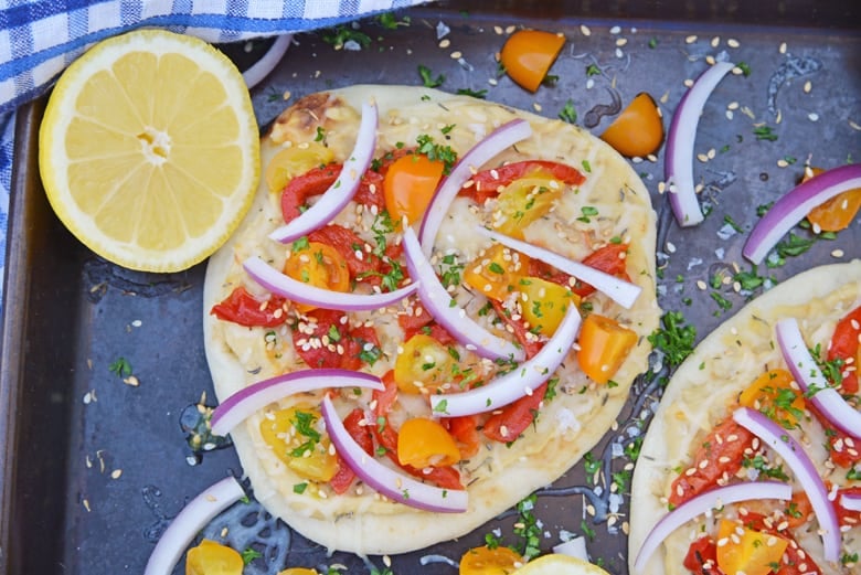 Overhead shot of vegetable flatbread with onions, tomato and roasted red pepper 