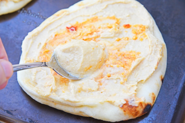 Hummus spreading onto a flatbread 
