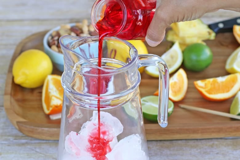 Grenadine pouring into a pitcher 
