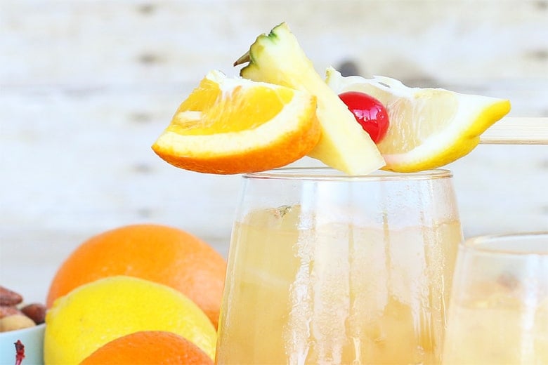 Fresh fruit on a toothpick garnishing a glass of fruit punch 