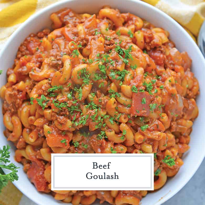 Overhead view of beef goulash with tomatoes, bell peppers and parsley garnish 