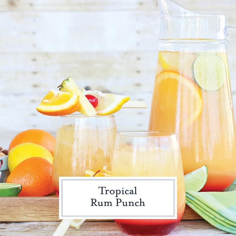 Pitcher and two glasses of rum punch with fresh fruit