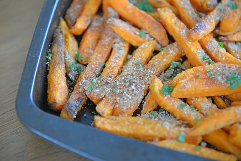 Brown sugar caramelized on sweet potato fries on a baking sheet 